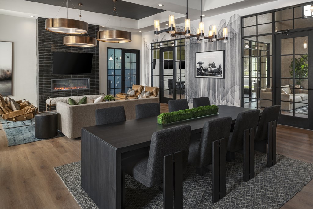 A modern dining room with a black table and chairs.