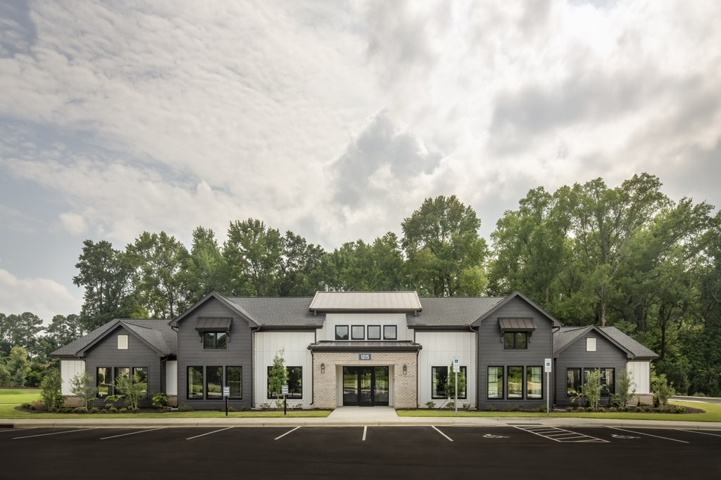 A large, modern building with a parking lot in front.