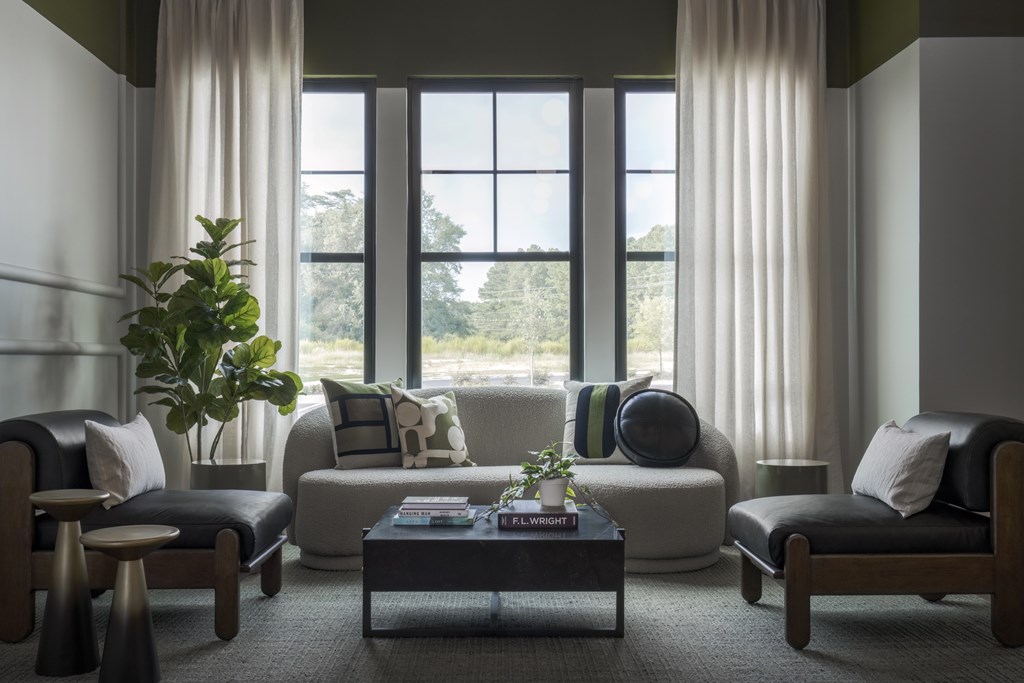 A living room with a large window and comfortable furniture.