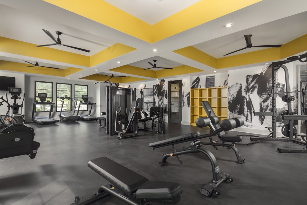 A gym with a variety of equipment including weights and machines.