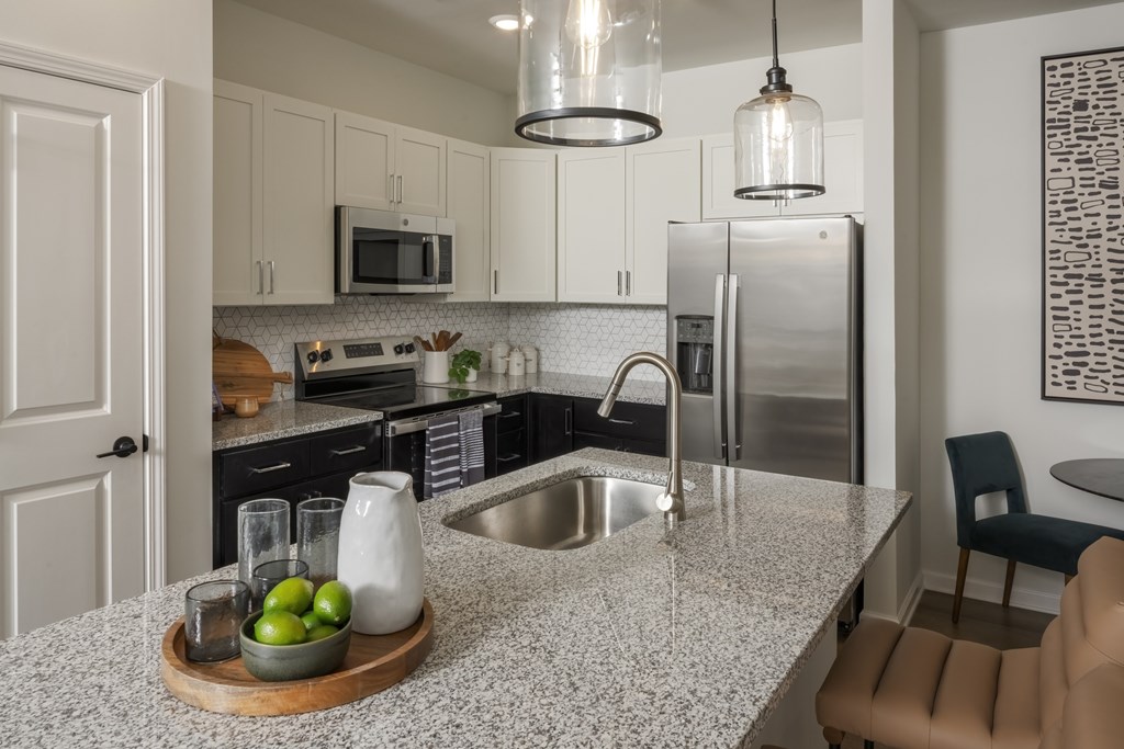 A kitchen with a granite countertop and stainless steel appliances.