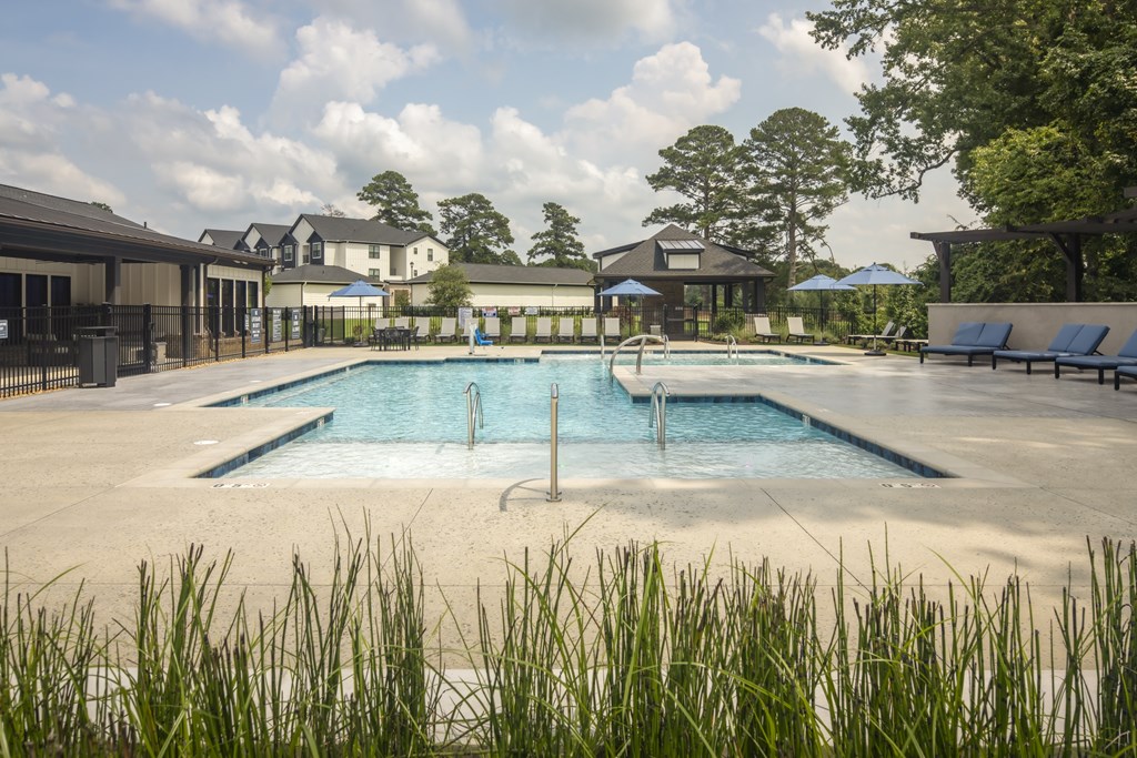 A large outdoor swimming pool surrounded by grass.