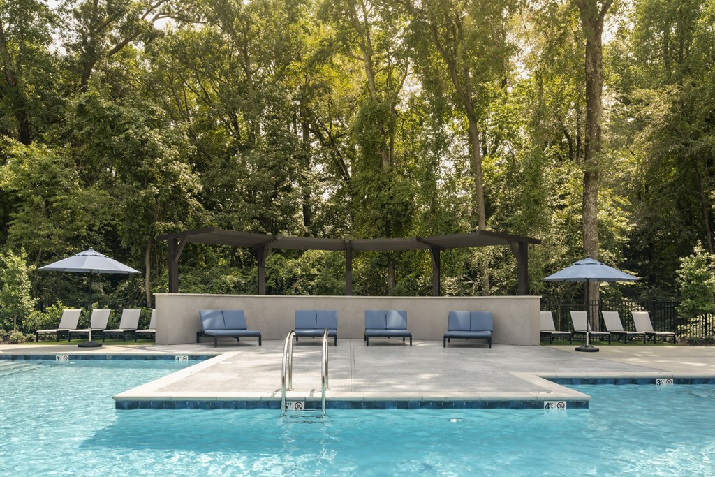 A pool with a deck and sun loungers.