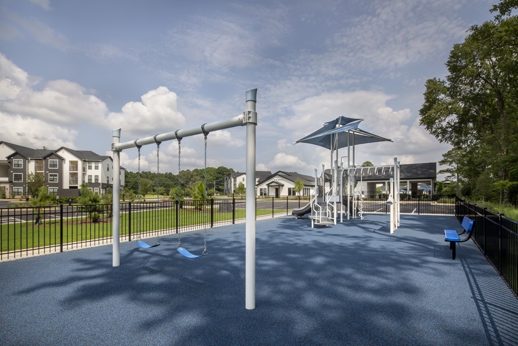 A playground with a blue swing set and a slide.