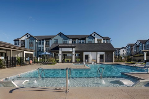 A large swimming pool in front of a building at Evolve Deep River Apartments in High Point, NC