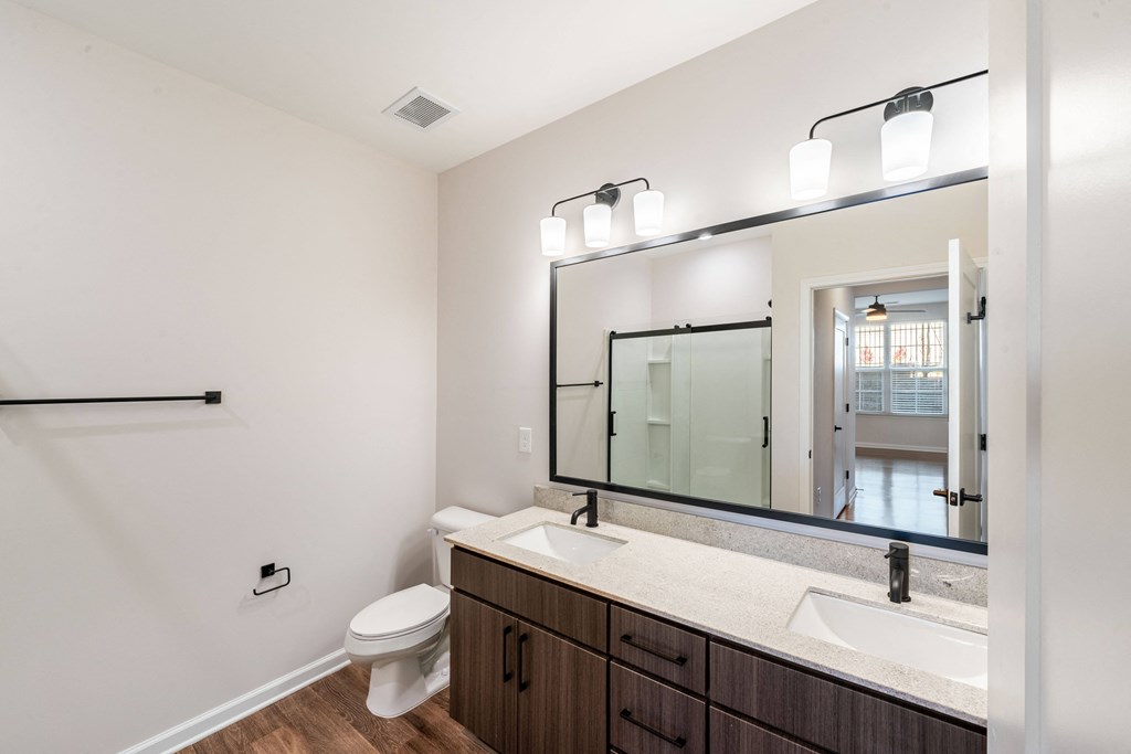 a bathroom with a large mirror and a sink and a toilet