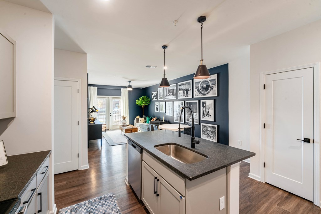 an open kitchen and living room with a sink and a counter top