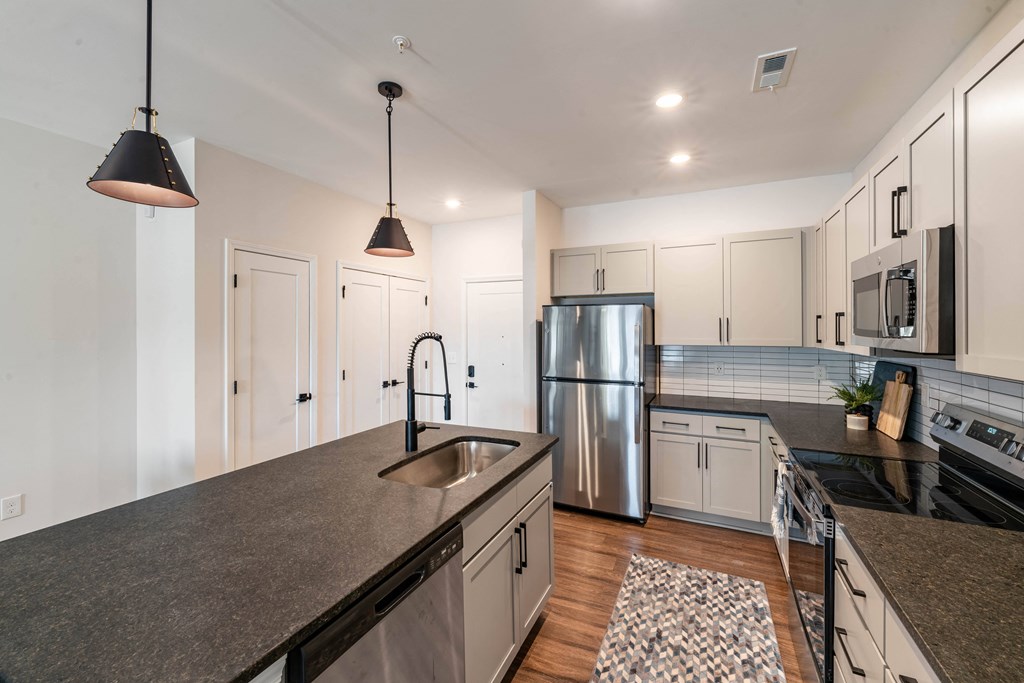a kitchen with white cabinets and a stainless steel refrigerator