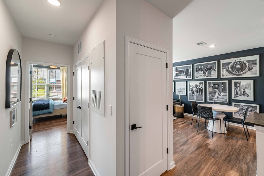a living room with white doors and a dining room with a table and chairs