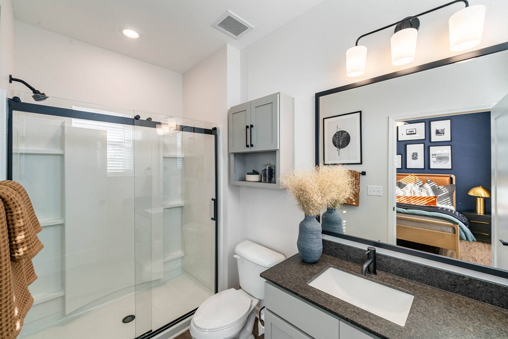 a bathroom with a shower and a sink and a mirror