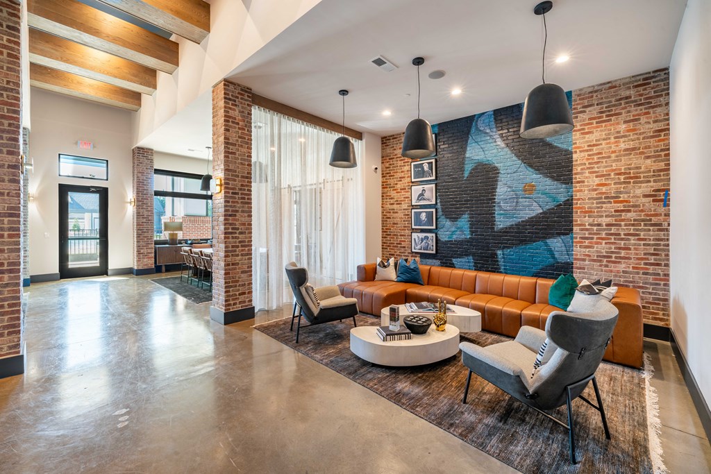 a living room with a couch and a table in front of a brick wall