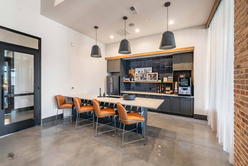 a kitchen with a long table and chairs in front of a brick wall
