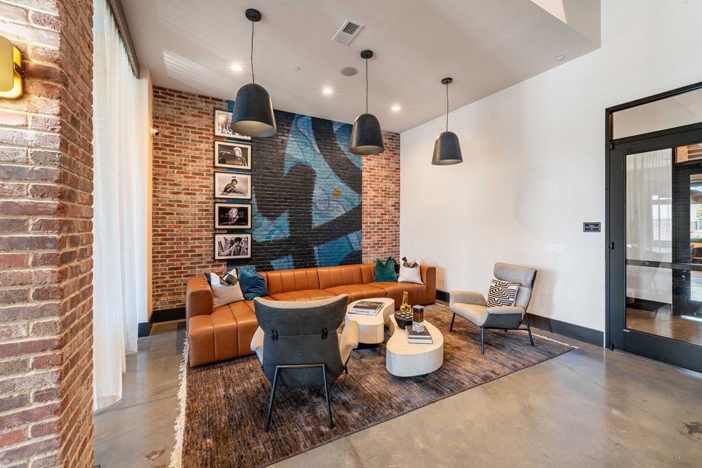 a living room with a brick wall and leather furniture