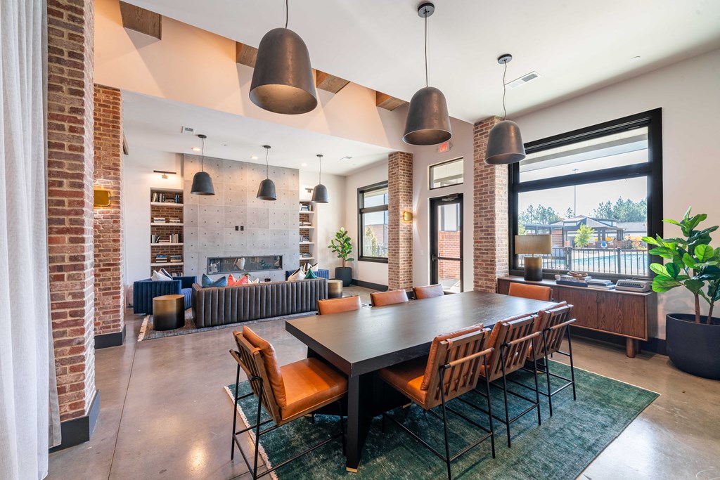 a dining room with a long table and chairs and a living room with fireplace