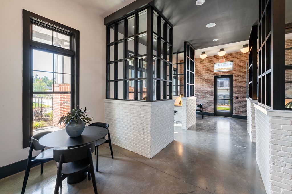 a dining area with a table and chairs in a large room with windows