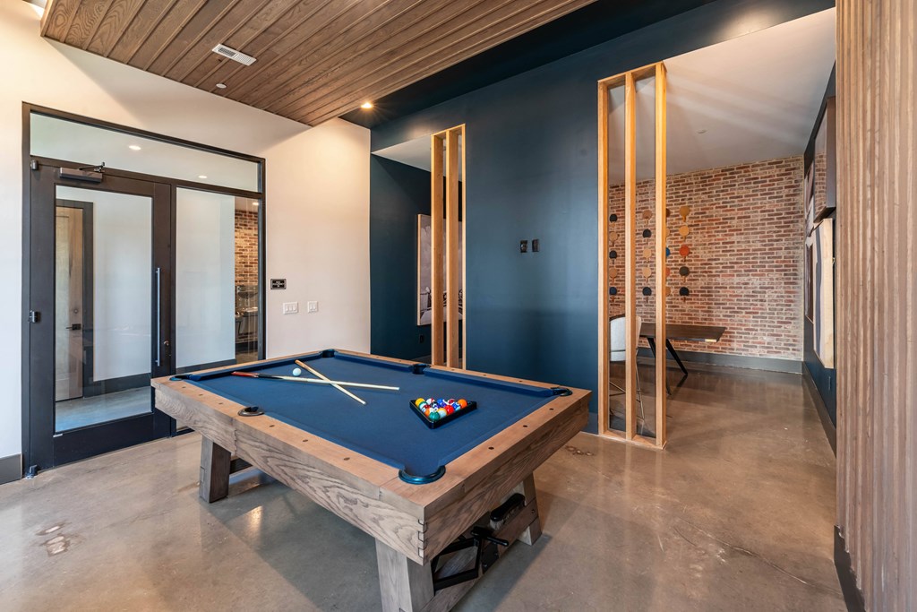 a pool table in a house with a brick wall