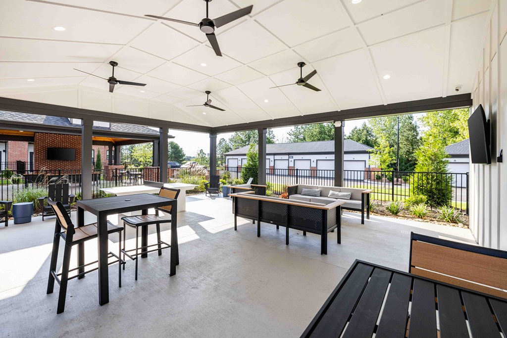 A patio with a table and chairs and a ceiling fan.