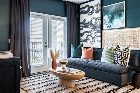 A living room with a dark blue sofa and a wooden coffee table.