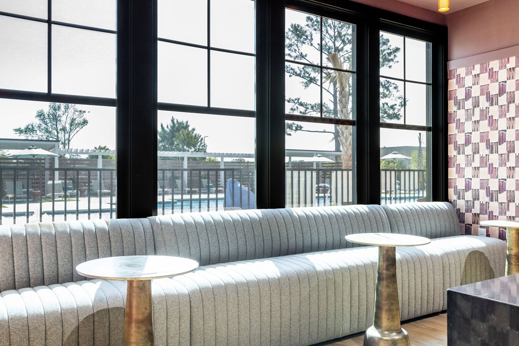 A grey couch with a white table in front of a window. at Evolve Waterford Apartments in Belville, NC