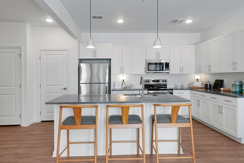 A kitchen with white cabinets and a black countertop.