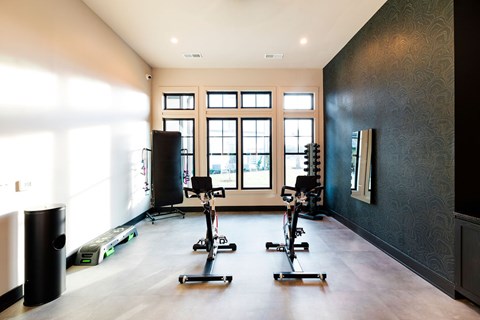 A room with a row of exercise bikes and a window.