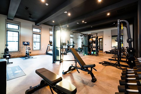 A gym with a variety of equipment including weights and exercise machines.