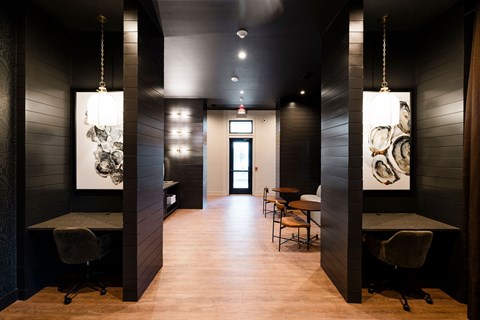 A long hallway with chairs and artwork on the walls.