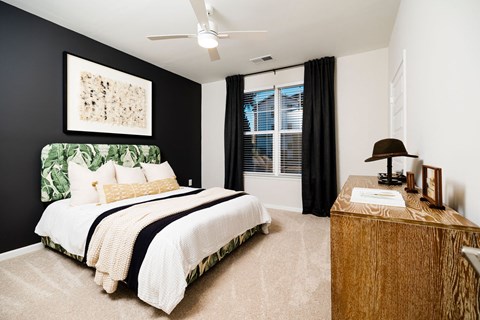 A bedroom with a large bed and a wooden dresser.