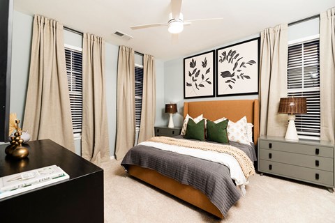 A bedroom with a bed, nightstand, and a dresser.