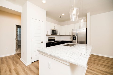 A kitchen with a marble countertop and stainless steel appliances.