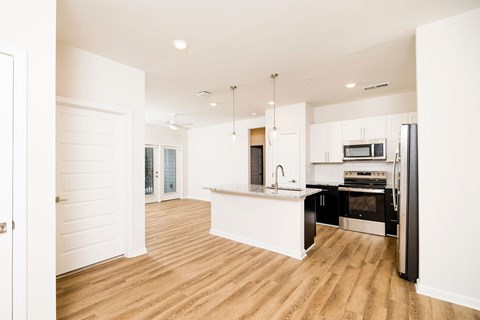 A kitchen with white cabinets and black appliances.