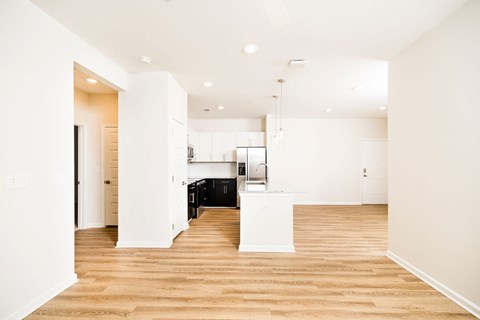 A kitchen area with a white counter and a black fridge.