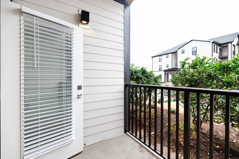 A white door with a black handle is on a white house.