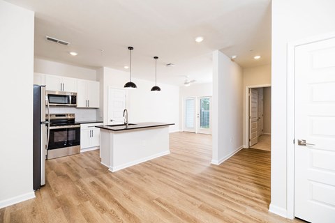 A kitchen with white cabinets and a black countertop.