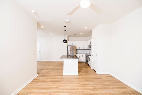 A kitchen with a white island and a ceiling fan.