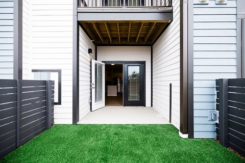 A modern house with a white exterior and a black gate.