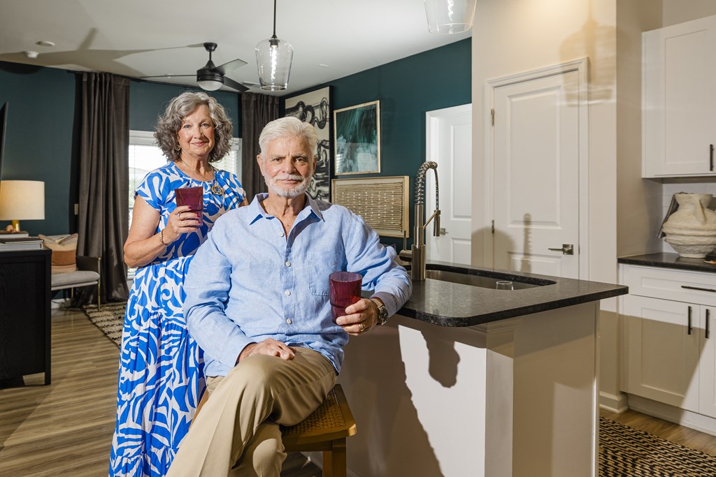 A man and woman are sitting in a kitchen.