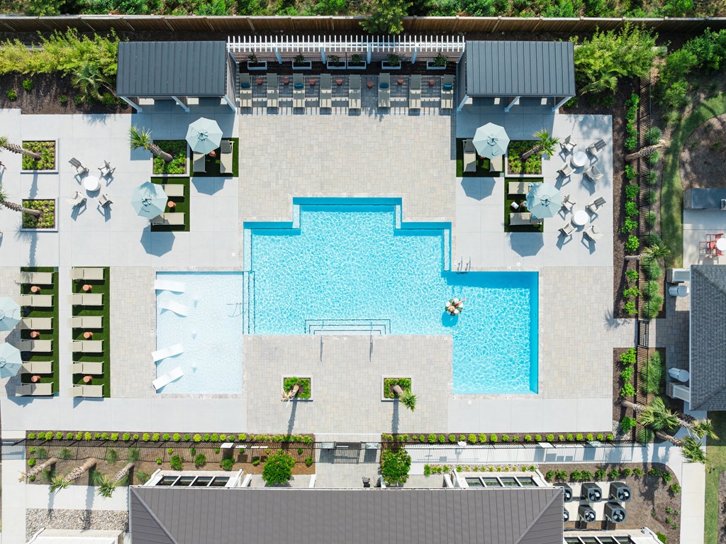 A large swimming pool surrounded by lounge chairs and umbrellas.