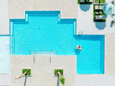 A person is floating in a blue pool.