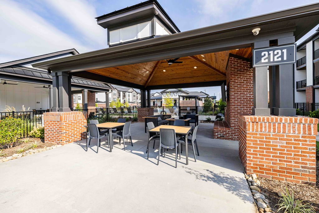 A patio with a table and chairs is covered by a roof.