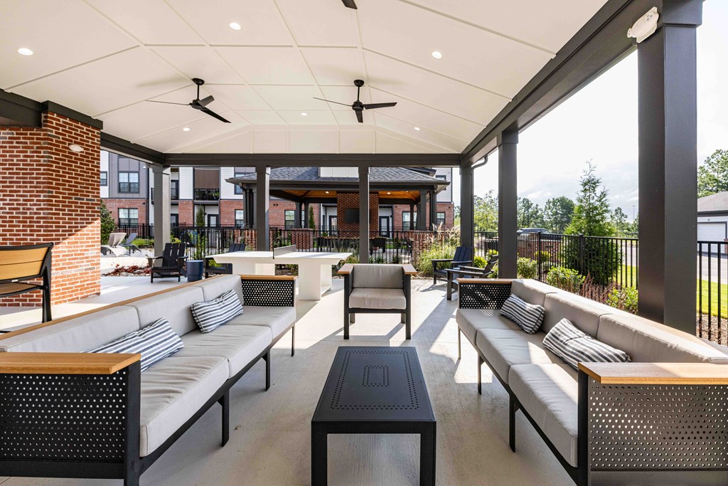 A patio with a white ceiling and black furniture.