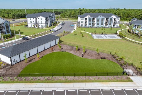 Dog park with a large grassy area fenced in.