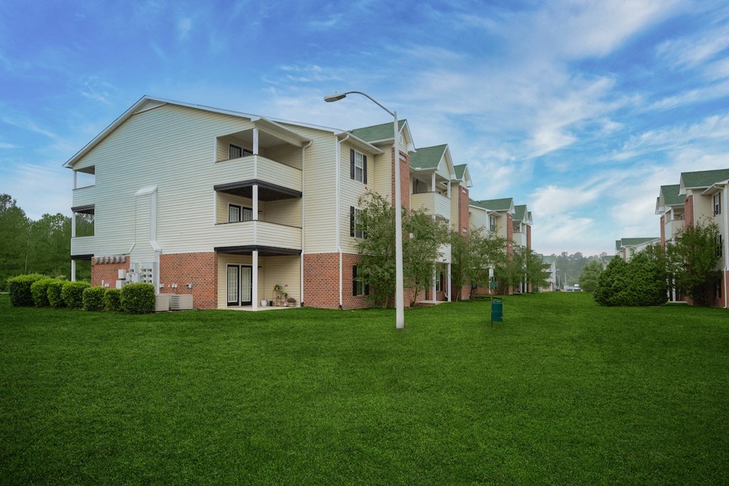 an apartment building with a green lawn in front of it