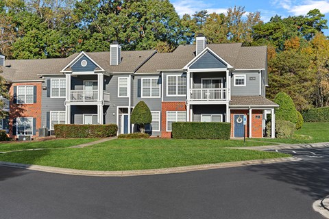 A grey apartment building with a balcony on the second floor at Hawthorne Bridford in Greensboro, NC.