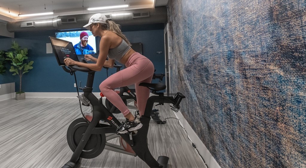 a woman riding an exercise bike in a gym