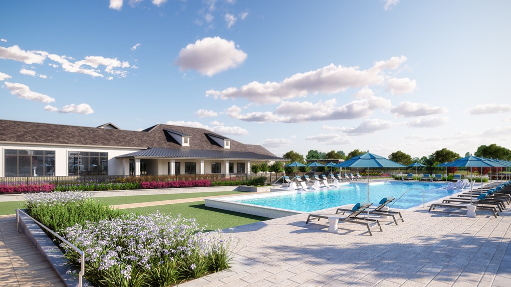 an aerial view of a swimming pool with lounge chairs and a building in the background