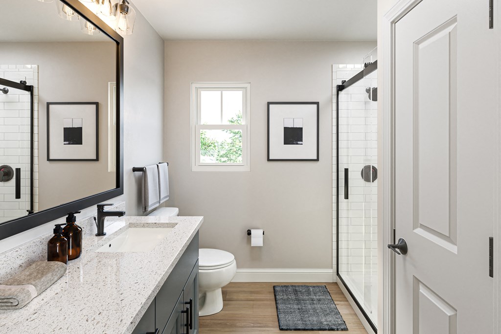 a bathroom with a large mirror and a toilet and a shower