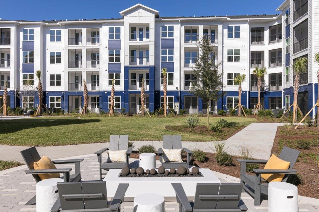 an outdoor area with a fire pit in front of an apartment building