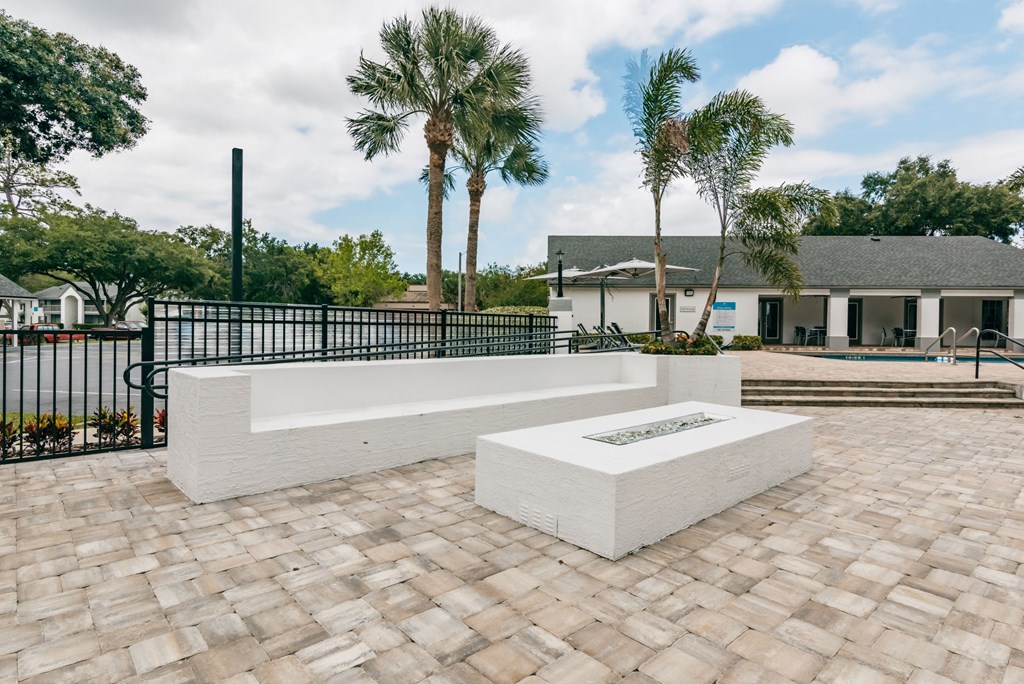a seating area on a brick patio with palm trees