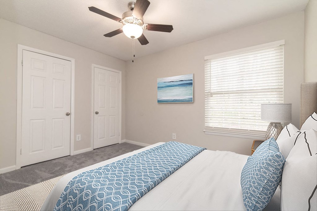 a bedroom with a large bed and a ceiling fan